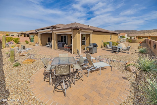 back of property featuring a fenced backyard, a patio, and stucco siding