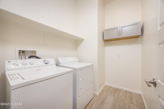 laundry area with light hardwood / wood-style flooring and washing machine and dryer