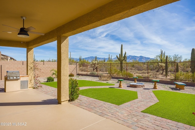 view of patio featuring a fire pit, area for grilling, ceiling fan, grilling area, and a mountain view