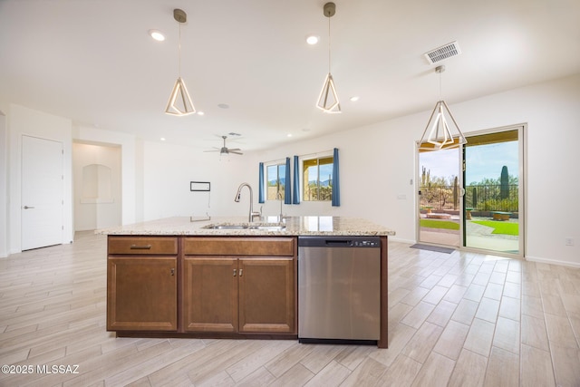 kitchen with sink, hanging light fixtures, a center island with sink, dishwasher, and a wealth of natural light