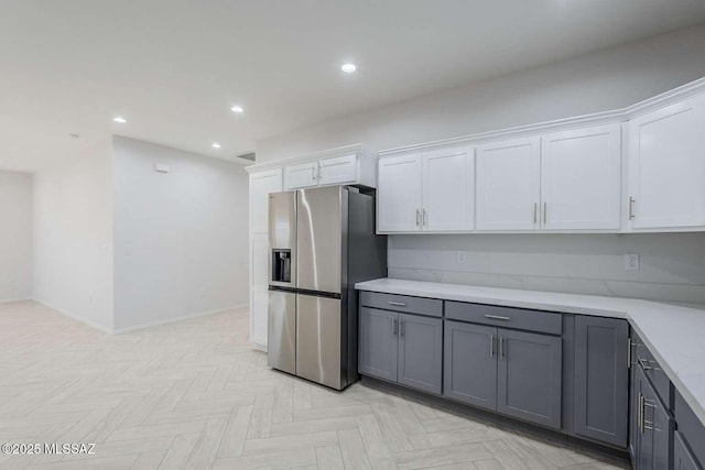 kitchen featuring stainless steel refrigerator with ice dispenser, gray cabinets, light parquet floors, and white cabinets