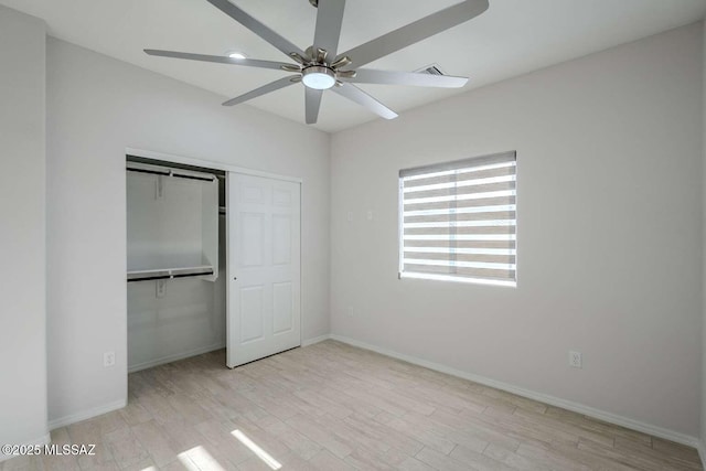 unfurnished bedroom featuring ceiling fan, a closet, and light wood-type flooring