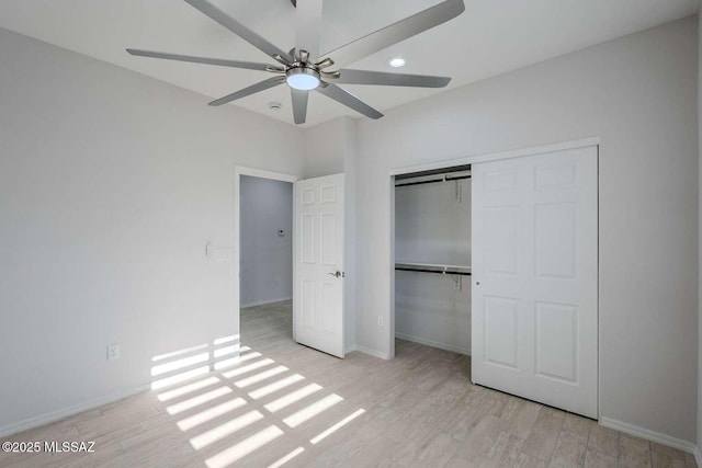 unfurnished bedroom featuring ceiling fan, light hardwood / wood-style floors, and a closet