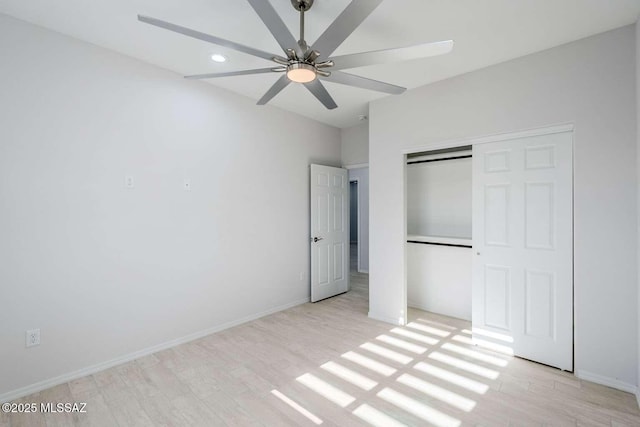 unfurnished bedroom featuring ceiling fan, a closet, and light hardwood / wood-style flooring