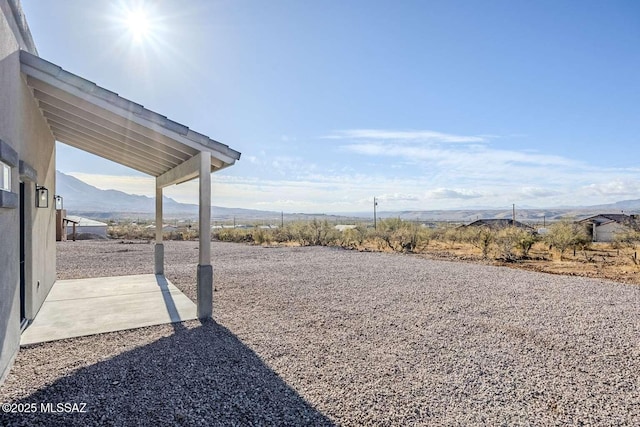 view of yard featuring a mountain view and a patio