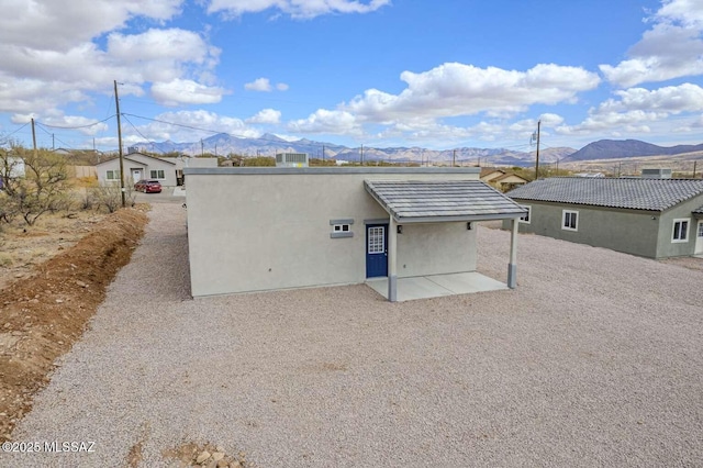 back of house featuring a mountain view and a patio