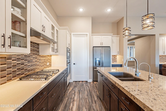 kitchen with white cabinetry, sink, hanging light fixtures, dark brown cabinetry, and stainless steel appliances