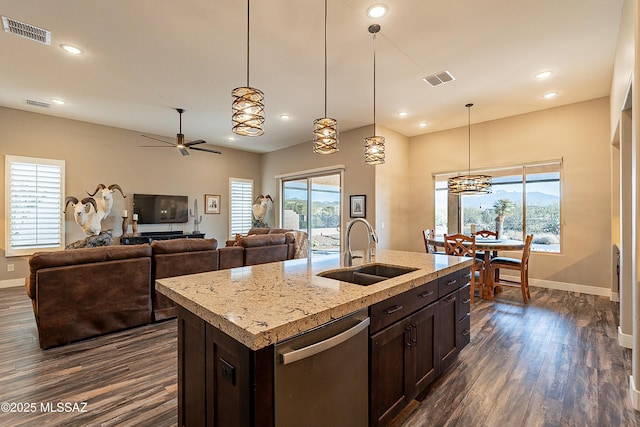 kitchen featuring a healthy amount of sunlight, dishwasher, an island with sink, sink, and dark brown cabinets