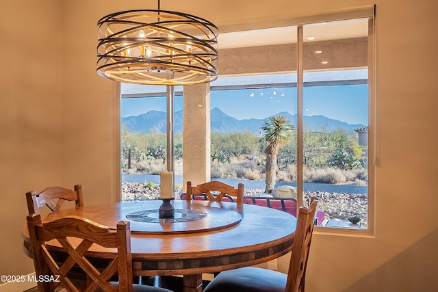 dining area featuring a water and mountain view and a notable chandelier