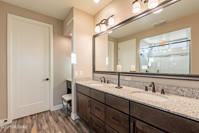 bathroom featuring hardwood / wood-style flooring, vanity, and an enclosed shower