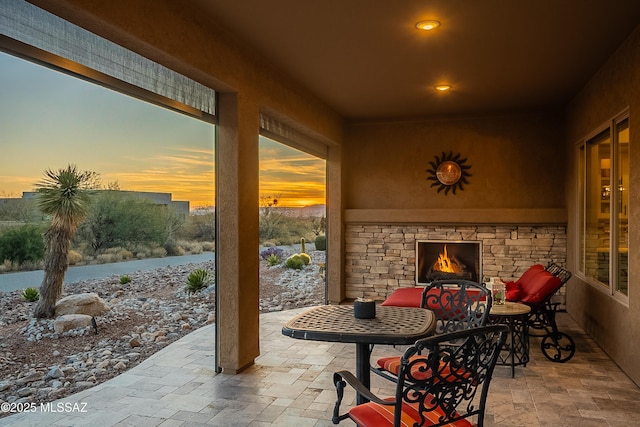 patio terrace at dusk with an outdoor stone fireplace