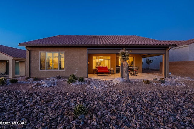 back house at dusk with a patio