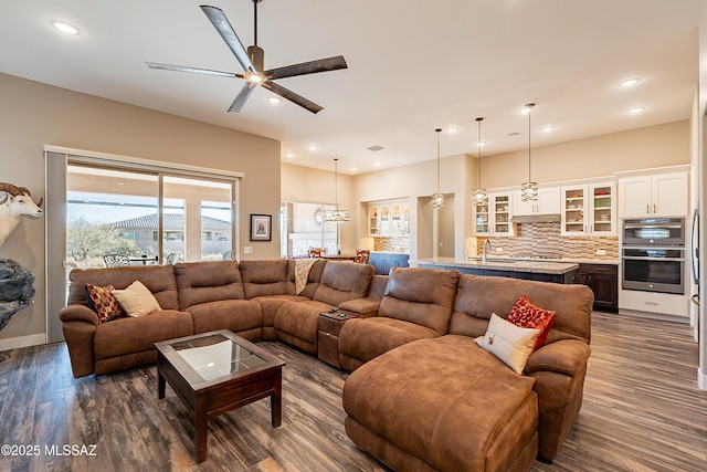 living room with ceiling fan, sink, and dark hardwood / wood-style flooring