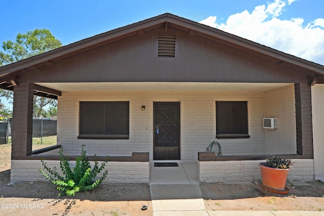 view of front facade featuring a wall unit AC