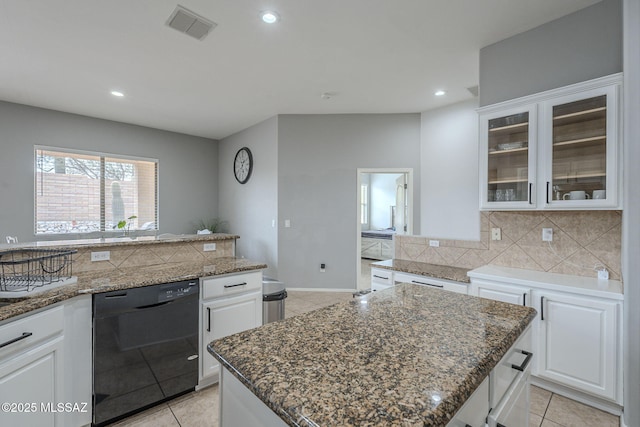 kitchen with dishwasher, white cabinetry, backsplash, a center island, and dark stone counters