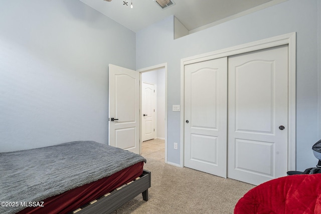 carpeted bedroom with vaulted ceiling and a closet