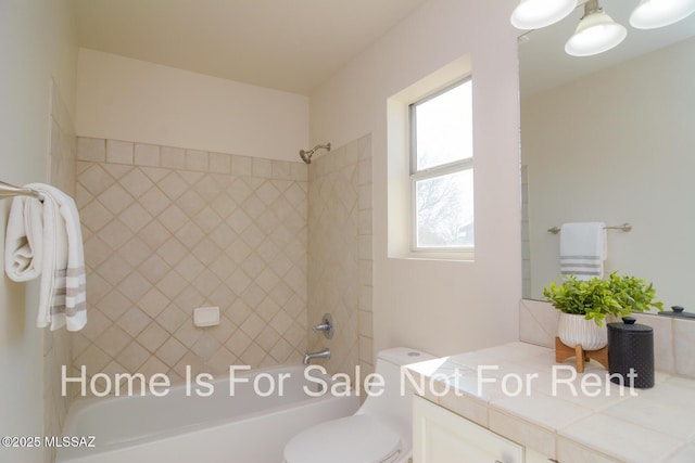 full bathroom featuring vanity, toilet, and tiled shower / bath combo