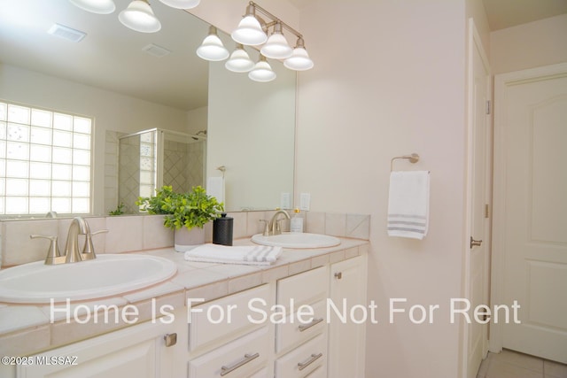 bathroom featuring tile patterned flooring, vanity, and walk in shower