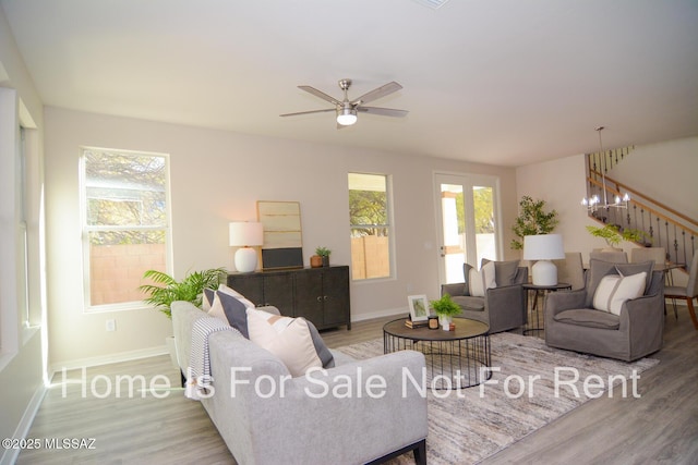 living room with ceiling fan, light wood-type flooring, and a wealth of natural light