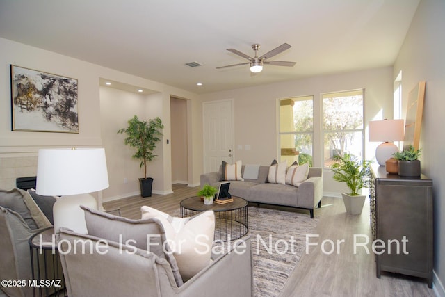 living room with ceiling fan and light wood-type flooring