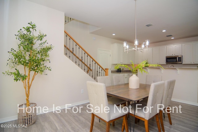 dining area featuring a notable chandelier and light hardwood / wood-style floors