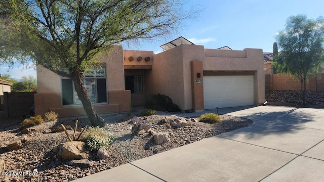 pueblo-style house featuring a garage