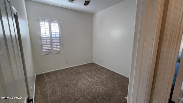 unfurnished room featuring ceiling fan and dark carpet