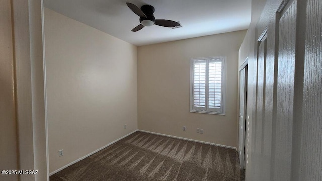 spare room featuring ceiling fan and dark carpet