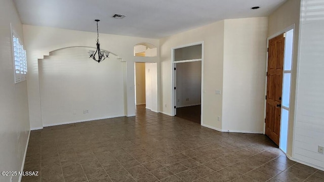 spare room featuring an inviting chandelier