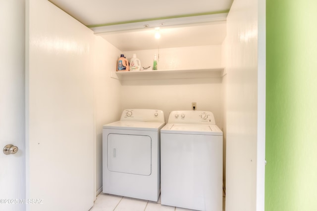 clothes washing area with light tile patterned floors and independent washer and dryer