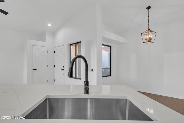 details with light stone counters, sink, and pendant lighting