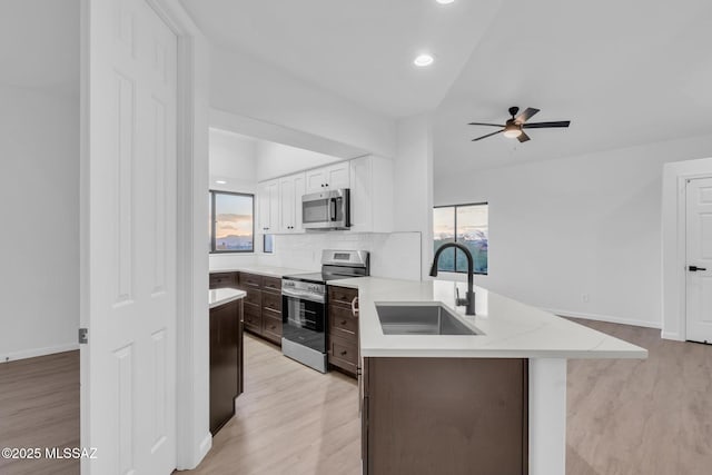 kitchen featuring sink, appliances with stainless steel finishes, white cabinetry, backsplash, and dark brown cabinets