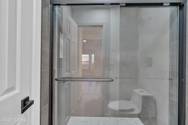 bathroom featuring an enclosed shower and toilet