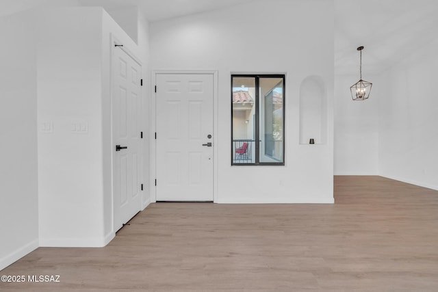 foyer entrance with light hardwood / wood-style flooring and a notable chandelier