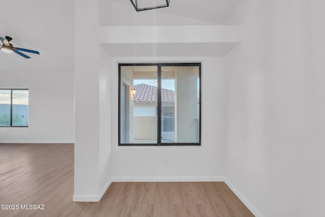 empty room with lofted ceiling, light hardwood / wood-style floors, and ceiling fan