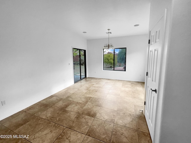 unfurnished room featuring a chandelier