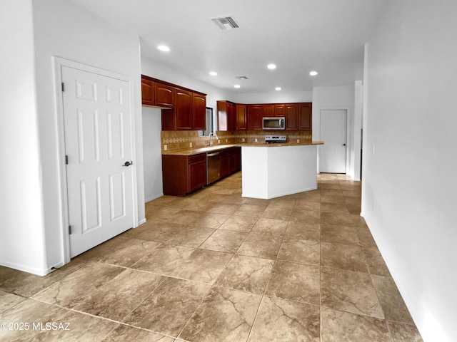 kitchen featuring tasteful backsplash, sink, stainless steel appliances, and a center island