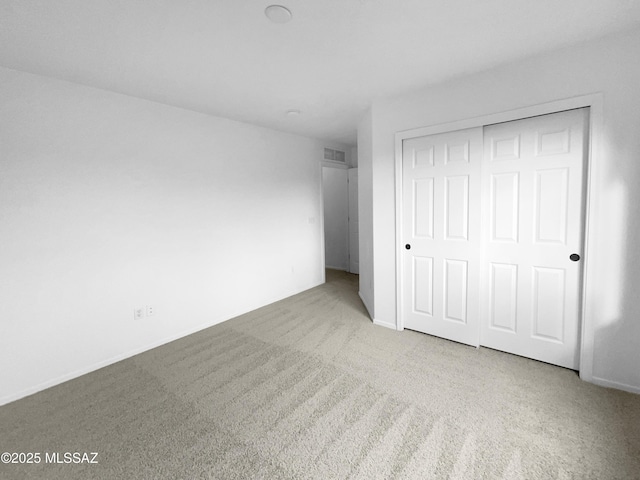 unfurnished bedroom featuring a closet and carpet flooring