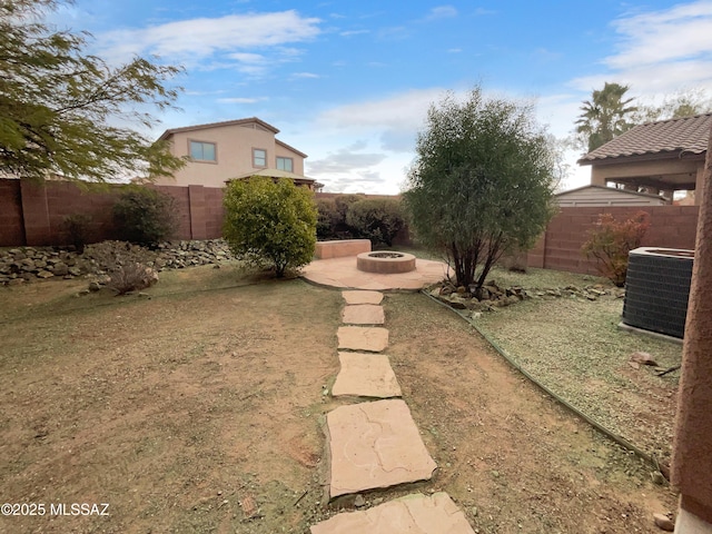 view of yard with cooling unit and an outdoor fire pit