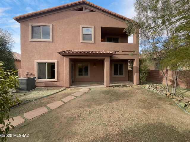 rear view of house with cooling unit, a yard, and a patio area