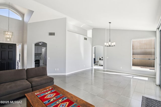 living room featuring high vaulted ceiling, a chandelier, and tile patterned flooring