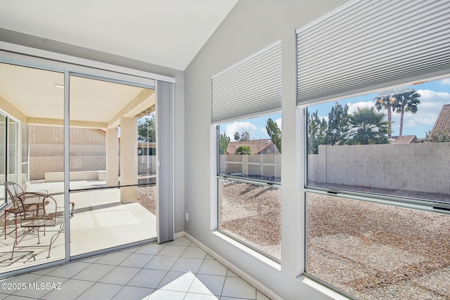 entryway with light tile patterned floors and vaulted ceiling