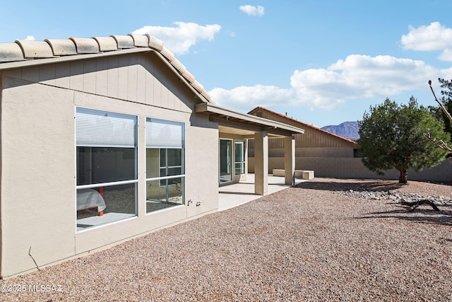 rear view of property featuring a mountain view and a patio