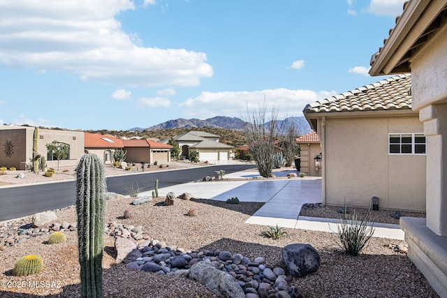 view of yard with a mountain view and a garage