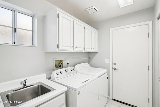 clothes washing area with cabinets, washing machine and dryer, sink, and light tile patterned floors