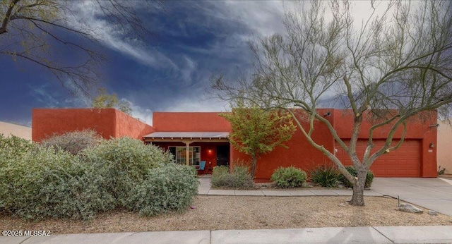 pueblo-style home featuring a garage