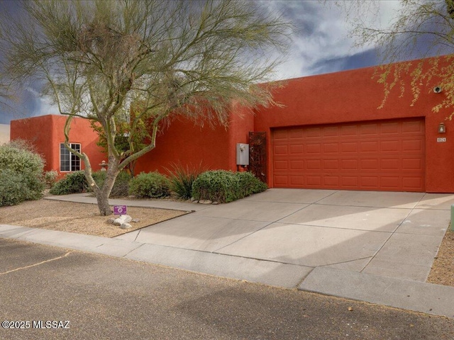 pueblo revival-style home featuring a garage