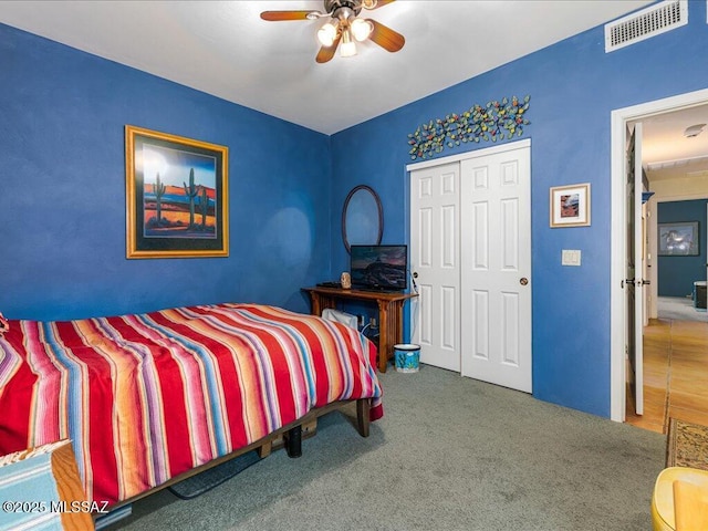 carpeted bedroom featuring a closet and ceiling fan