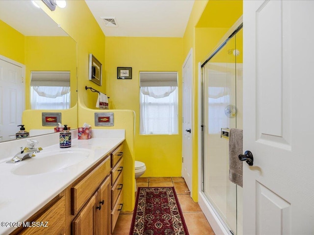 bathroom with vanity, a shower with door, tile patterned floors, and toilet