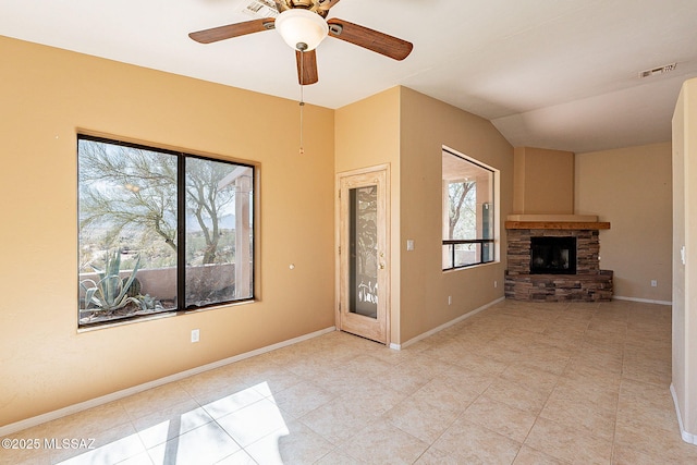 unfurnished living room featuring lofted ceiling, baseboards, visible vents, and a stone fireplace